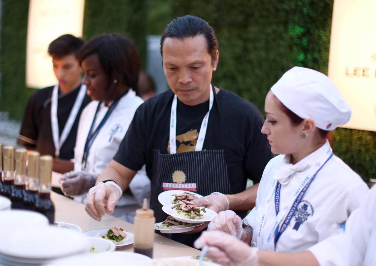 Susur Lee in black top and apron between three other chefs.