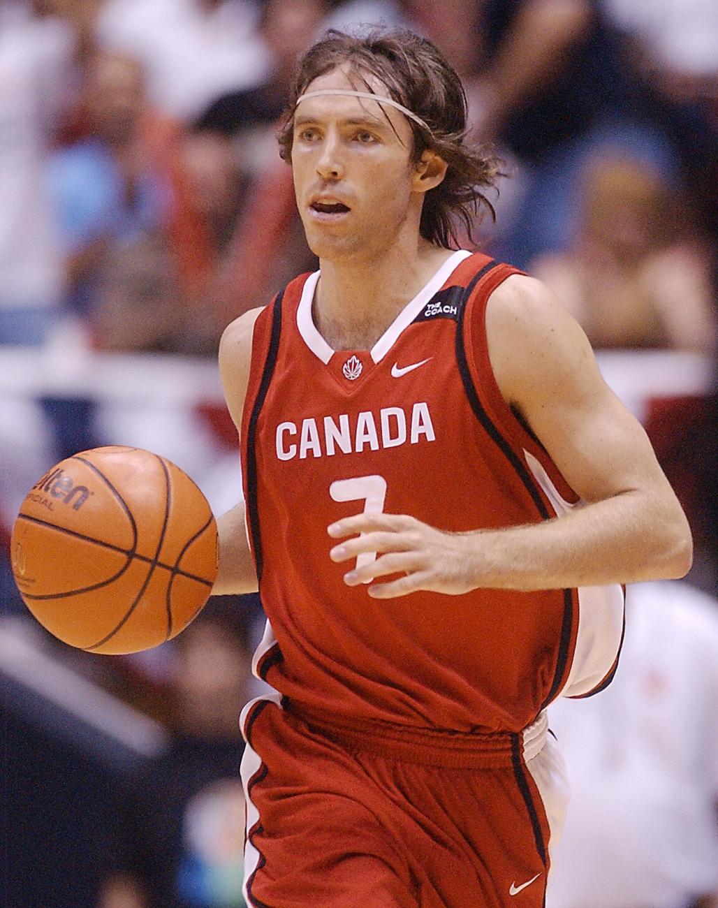 Steve Nash in red on basketball court holding the ball.