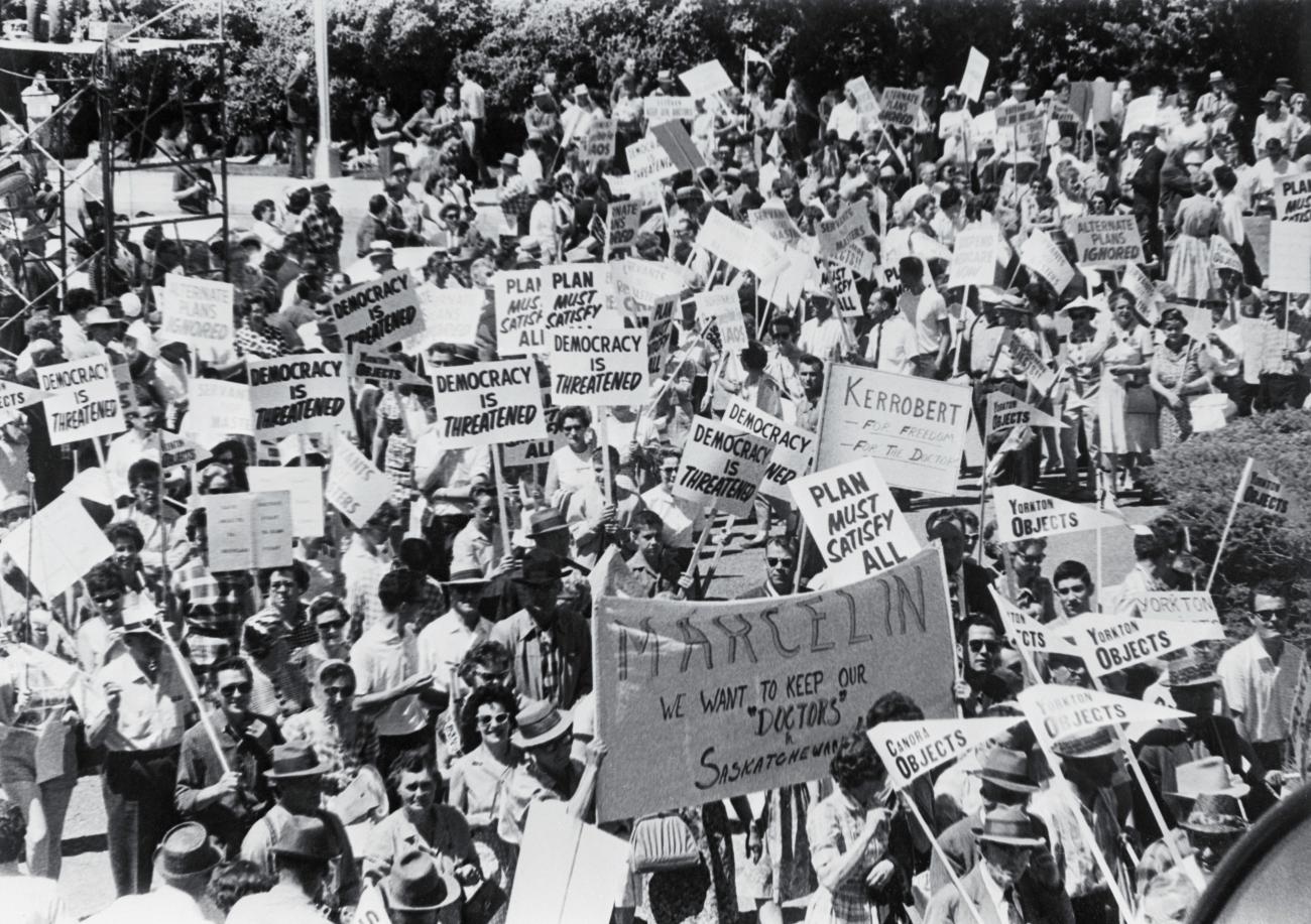 black and white photo of many people protesting holding signs and banners.