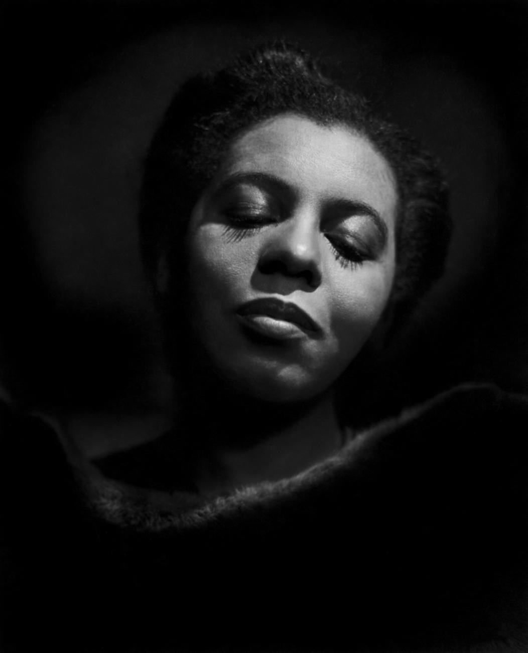 Black and white portrait of a woman with her eyes closed.